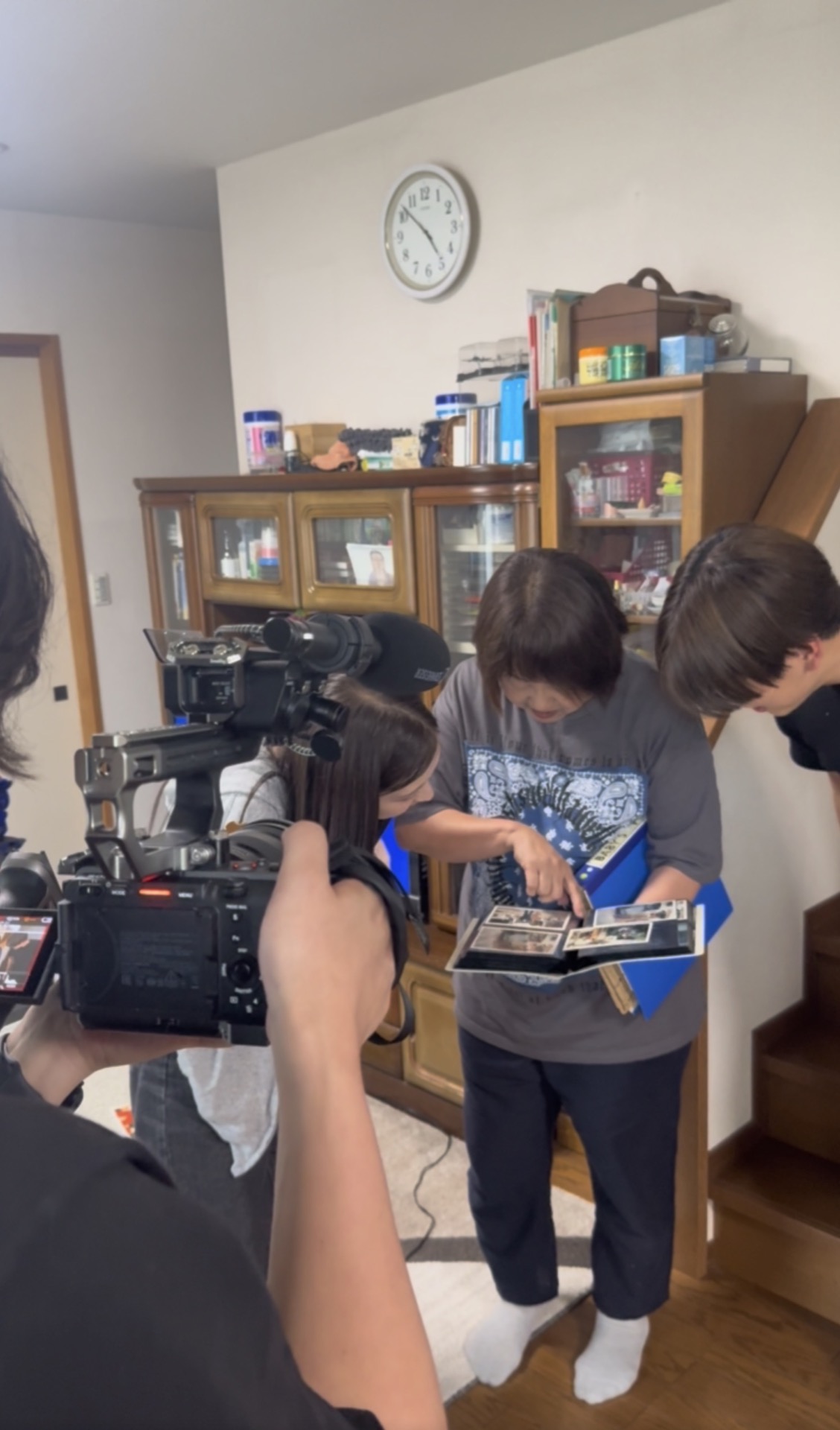 結びの映像制作で家族写真を見ながら撮影する現場